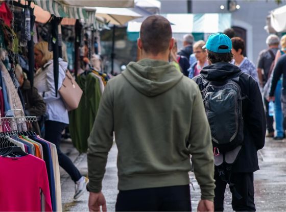 Individual walking confidently in an urban setting while observing his environment, demonstrating situational awareness.