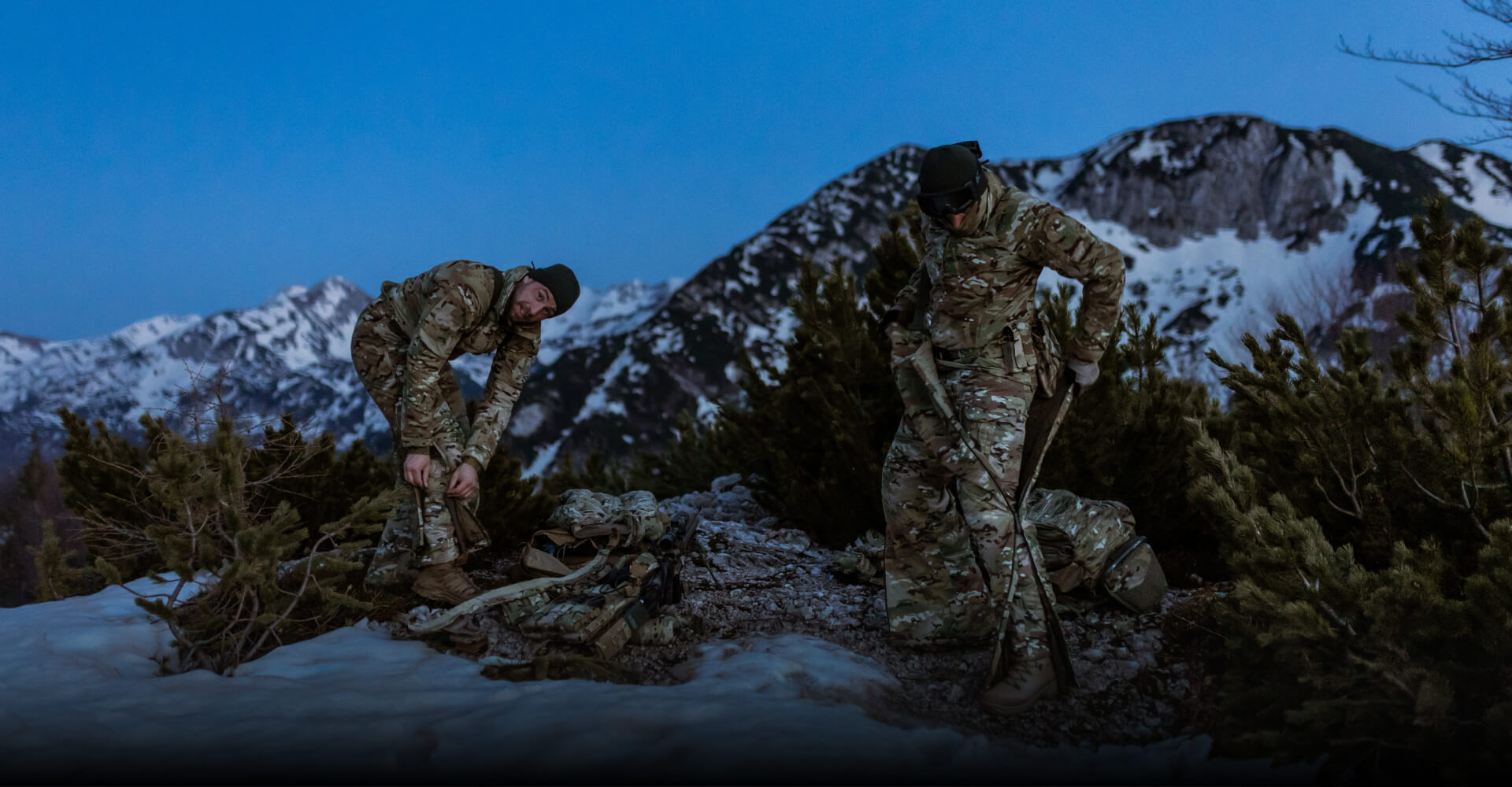 Soldiers are putting on an overall suit in the mountain in the winter.