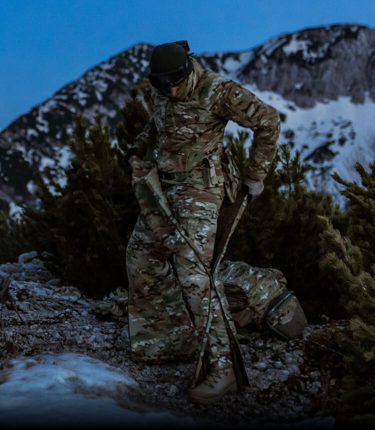 Soldiers are putting on an overall suit in the mountain in the winter.